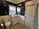 Cozy bathroom featuring a marble vanity top, cabinet, and a toilet at 195 E Vine St, Bartow, FL 33830