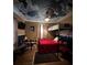 Unique bedroom with bunk beds, red bedding, and a ceiling painted with clouds and airplanes at 195 E Vine St, Bartow, FL 33830