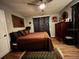 Comfortable bedroom with a ceiling fan, hardwood floors, stylish curtains, and an inviting bed at 195 E Vine St, Bartow, FL 33830