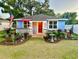 Charming single-story home with blue exterior, front porch, landscaped yard, and an American flag at 195 E Vine St, Bartow, FL 33830