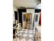 Kitchen area featuring stainless steel refrigerator, white decorative shelving, and checkerboard flooring for a distinctive look at 195 E Vine St, Bartow, FL 33830