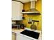 Updated kitchen with modern range hood, black cooktop, and white countertops at 195 E Vine St, Bartow, FL 33830
