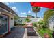 Relaxing backyard patio with comfortable seating, a fire pit, well-maintained brick pavers, and tropical landscaping at 2202 Starboard, Winter Haven, FL 33881