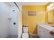Bathroom with bright yellow walls, tiled shower, and marble vanity top at 2202 Starboard, Winter Haven, FL 33881