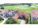 Stunning aerial view of a tile roof home overlooking a golf course and lake, featuring solar panels at 2340 Pinehurst Ct, Davenport, FL 33837