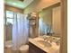 Well-lit bathroom with a shower-tub combination, vanity, and shelving for towels and toiletries at 2340 Pinehurst Ct, Davenport, FL 33837