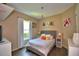 Bright bedroom with a gray upholstered bed, a large window and hardwood flooring at 2340 Pinehurst Ct, Davenport, FL 33837