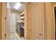 Bright laundry room featuring front-load washer/dryer, tiled floor, shelving, and a conveniently located linen closet at 2340 Pinehurst Ct, Davenport, FL 33837