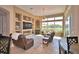 Spacious living room with built-in shelves, a fireplace, and large windows overlooking the outdoor area at 2340 Pinehurst Ct, Davenport, FL 33837