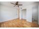 Bright bedroom features cork flooring, ceiling fan, closet, and adjacent half bathroom at 2409 E Civitan Ave, Lakeland, FL 33801
