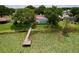 Beautiful backyard featuring a private dock and screened pool surrounded by lush greenery at 255 Lake Link Rd, Winter Haven, FL 33884