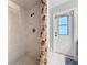 Bathroom showing tiled shower with seashell patterned curtain and white door at 255 Lake Link Rd, Winter Haven, FL 33884