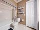 Neutral bathroom with shelves, decorations, white tiled shower over tub and white door at 255 Lake Link Rd, Winter Haven, FL 33884