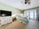 Bedroom view showcases patio access, television, modern lighting, and a view to the en suite bathroom at 255 Lake Link Rd, Winter Haven, FL 33884