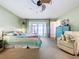 Brightly lit bedroom with ceiling fan, outdoor access, light-colored carpet, and soft pastel accents at 255 Lake Link Rd, Winter Haven, FL 33884