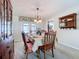 Dining room features classic wooden furniture, an elegant chandelier, and views to the pool at 255 Lake Link Rd, Winter Haven, FL 33884