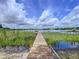 Picturesque view from the dock extends over a serene lake, framed by a blue sky and fluffy clouds at 255 Lake Link Rd, Winter Haven, FL 33884