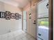 Bright foyer with white tiled floors and decorative wall art, leading to a screened porch at 255 Lake Link Rd, Winter Haven, FL 33884
