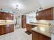 Spacious kitchen featuring wooden cabinetry, tiled floor, and an open view to the pool area at 255 Lake Link Rd, Winter Haven, FL 33884