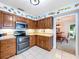 Bright kitchen features tiled floors, wood cabinets, and stainless steel appliances with an adjacent dining area at 255 Lake Link Rd, Winter Haven, FL 33884