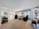 Bright living room with carpet flooring, large windows, comfortable seating, and a piano at 255 Lake Link Rd, Winter Haven, FL 33884
