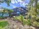 Pool area includes green vegetation and view of a blue umbrella inside screened enclosure at 255 Lake Link Rd, Winter Haven, FL 33884