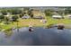 Aerial view features a lakefront house with a private dock, surrounded by lush landscape at 2731 State Road 557, Lake Alfred, FL 33850
