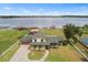 Aerial view of lakefront property featuring a well-maintained lawn, private dock, and multiple outbuildings at 2731 State Road 557, Lake Alfred, FL 33850