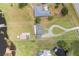 Aerial view showcasing the property's layout, large yard, mature trees, and proximity to nearby waterways at 2731 State Road 557, Lake Alfred, FL 33850