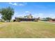 Expansive backyard features a lush lawn, mature trees, and a screened-in patio at 2731 State Road 557, Lake Alfred, FL 33850