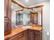 Bathroom with granite countertop, wooden cabinets, and corner mirrors reflecting a tiled shower at 2731 State Road 557, Lake Alfred, FL 33850