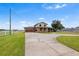 Two-story home with brick facade, attached garage, large driveway, and green awnings on a spacious lawn at 2731 State Road 557, Lake Alfred, FL 33850