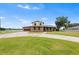 Charming two-story home with brick facade, lush lawn, circular driveway, and green awnings provides curb appeal at 2731 State Road 557, Lake Alfred, FL 33850