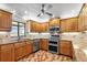 Traditional kitchen with wood cabinets, tile backsplash, stainless appliances, granite countertops and lake view at 2731 State Road 557, Lake Alfred, FL 33850