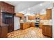 Traditional kitchen featuring wood cabinets, granite countertops, stainless steel appliances, and tiled floors at 2731 State Road 557, Lake Alfred, FL 33850