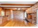 Living room features exposed brick wall, wood paneling, hardwood floors, and wood beams at 2731 State Road 557, Lake Alfred, FL 33850