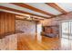 Open living room boasts exposed brick, wood beams, hardwood floors, and a classic fireplace at 2731 State Road 557, Lake Alfred, FL 33850