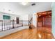 Second floor open-concept area with hardwood floors, white rug, and staircase access at 2731 State Road 557, Lake Alfred, FL 33850