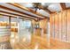 Spacious living room with wood beam ceiling, hardwood floors, and wood paneling at 2731 State Road 557, Lake Alfred, FL 33850