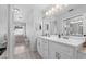 Well-lit bathroom with double vanity, framed mirrors, and separate tub area at 2987 Plantation Rd, Winter Haven, FL 33884