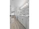 Well-lit bathroom with double vanity, framed mirrors, and separate tub area at 2987 Plantation Rd, Winter Haven, FL 33884