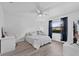 Well-lit bedroom featuring wood floors, bright white walls, a ceiling fan, and black-out curtains at 2987 Plantation Rd, Winter Haven, FL 33884