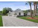 Charming one-story home with a paved driveway, lush lawn, and mature palm trees at 2987 Plantation Rd, Winter Haven, FL 33884
