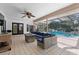 Expansive covered patio with wicker furniture, a fire pit, and direct access to the pool area at 2987 Plantation Rd, Winter Haven, FL 33884