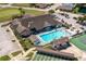 Aerial view of community clubhouse with pool, tennis courts, shuffleboard courts, and ample parking at 3245 Prairie Dunes E Cir, Lakeland, FL 33810