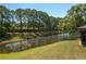 A tranquil backyard adjoins a scenic pond with lush trees providing privacy and nature views at 3245 Prairie Dunes E Cir, Lakeland, FL 33810