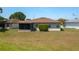 A spacious, grassy backyard features a screened lanai and mature landscaping for privacy at 3245 Prairie Dunes E Cir, Lakeland, FL 33810