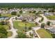 An aerial view reveals the community clubhouse and golf course, nestled among lush landscaping at 3245 Prairie Dunes E Cir, Lakeland, FL 33810