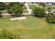 An aerial view shows manicured golf greens, a bunker and neighborhood near the community clubhouse at 3245 Prairie Dunes E Cir, Lakeland, FL 33810