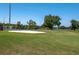 Scenic view of the golf course featuring lush green grass and a sand bunker at 3245 Prairie Dunes E Cir, Lakeland, FL 33810